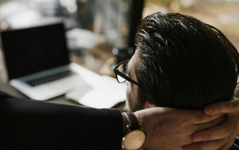 Man relaxed at his desk, hands behind his head, enjoying a smooth Solance onboarding experience