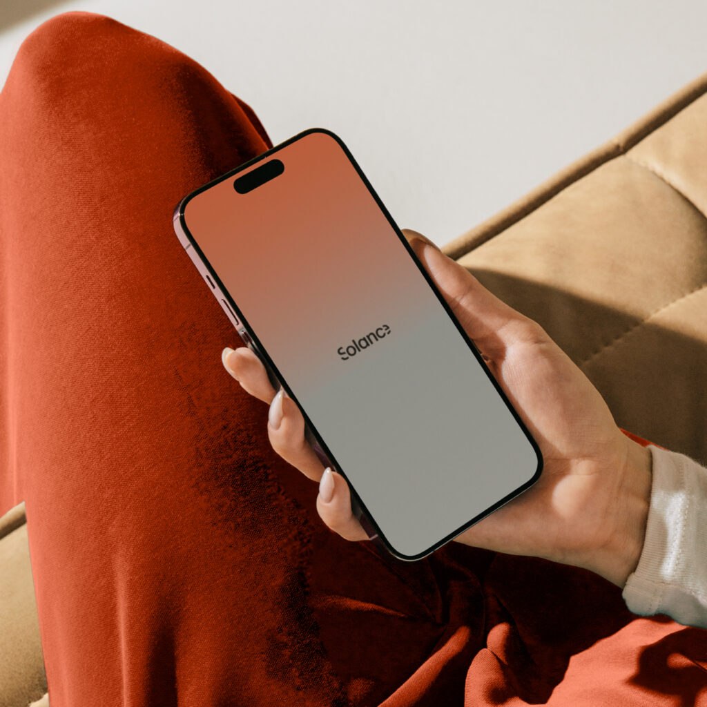 Person holding a phone with the Solance app, representing a career opportunity building exceptional financial products